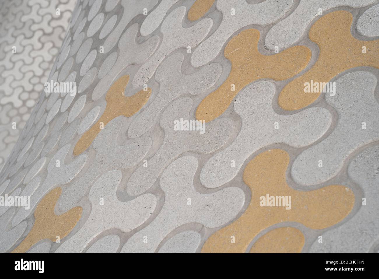 Moderner dekorativer Betonpflaster mit organisch fließenden Mustern in Grau und Gelb Stockfoto