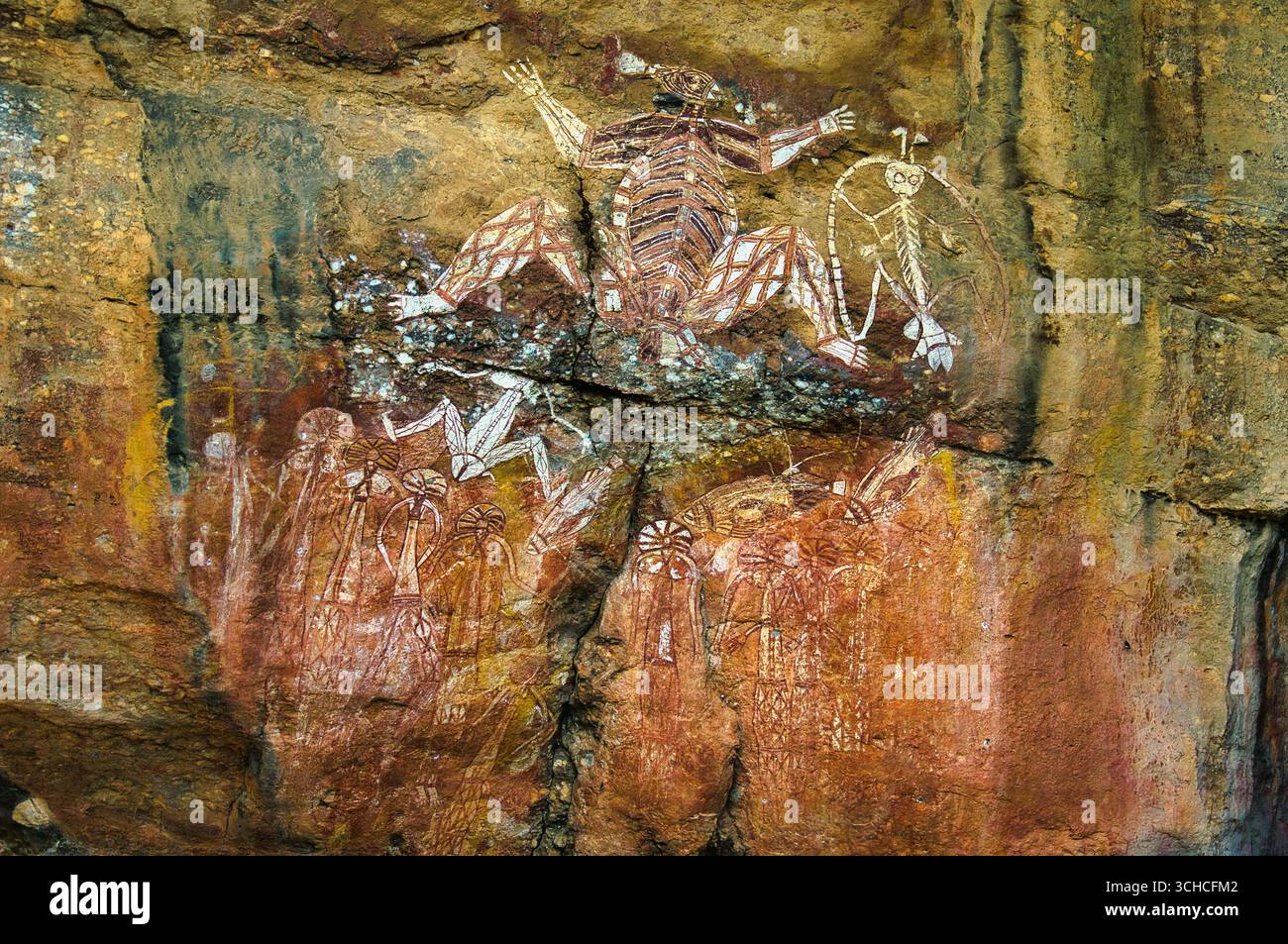 Figuren aus den Mythen der Aborigines und ein Volk mit zeremonieller Kopfbedeckung, Nourlangie (Burrunkuy), Arnhem Land, Kakadu, Northern Territory, Australien Stockfoto