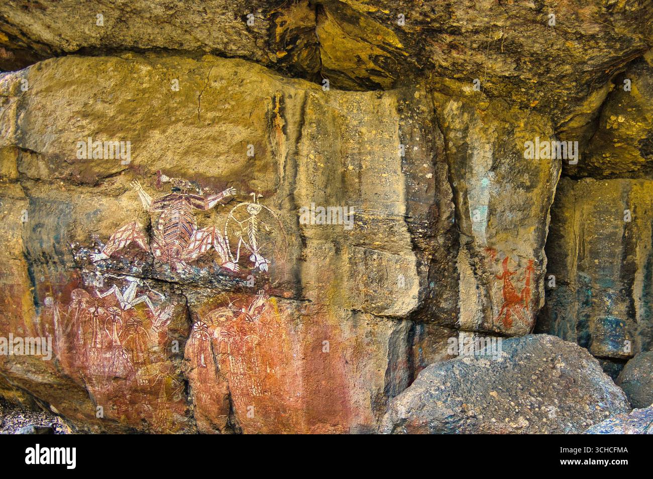Figuren aus den Mythen der Aborigines und ein Volk mit zeremonieller Kopfbedeckung, Nourlangie (Burrunkuy), Arnhem Land, Kakadu, Northern Territory, Australien Stockfoto