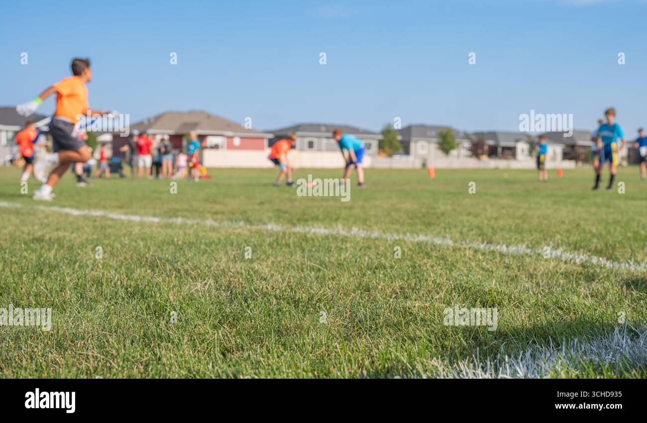 Jugend-Fußball-Training an einem sonnigen Tag auf einem geräumigen Feld mit Kindern in verschiedenen Uniformen Stockfoto