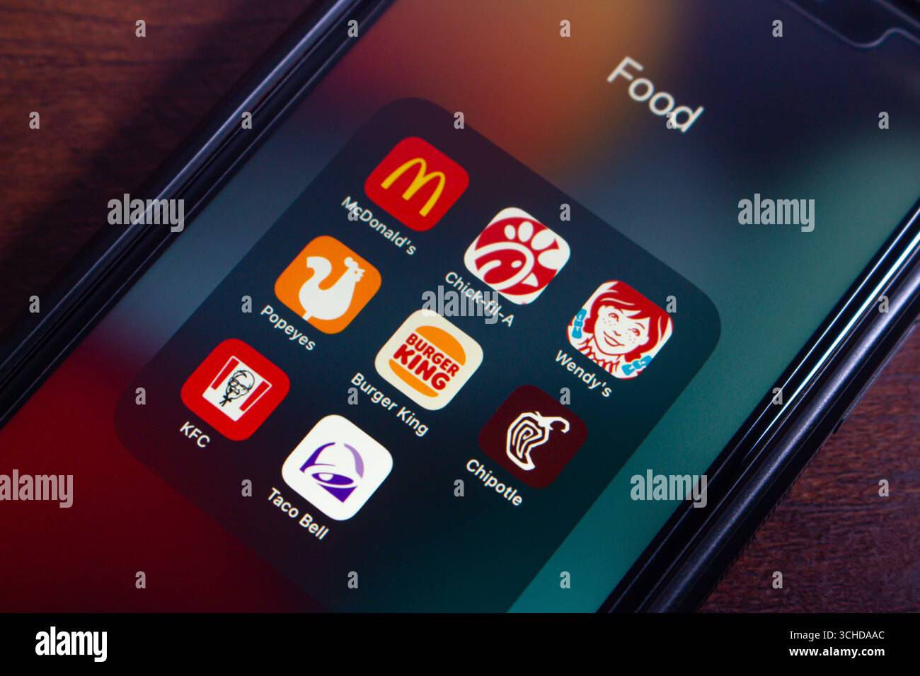 Mobiltelefon-Bildschirm mit einem Ordner mit dem Titel „Food“ mit verschiedenen Fast-Food-Apps wie McDonald's, Chick-Fil-A und Wendy's. Stockfoto
