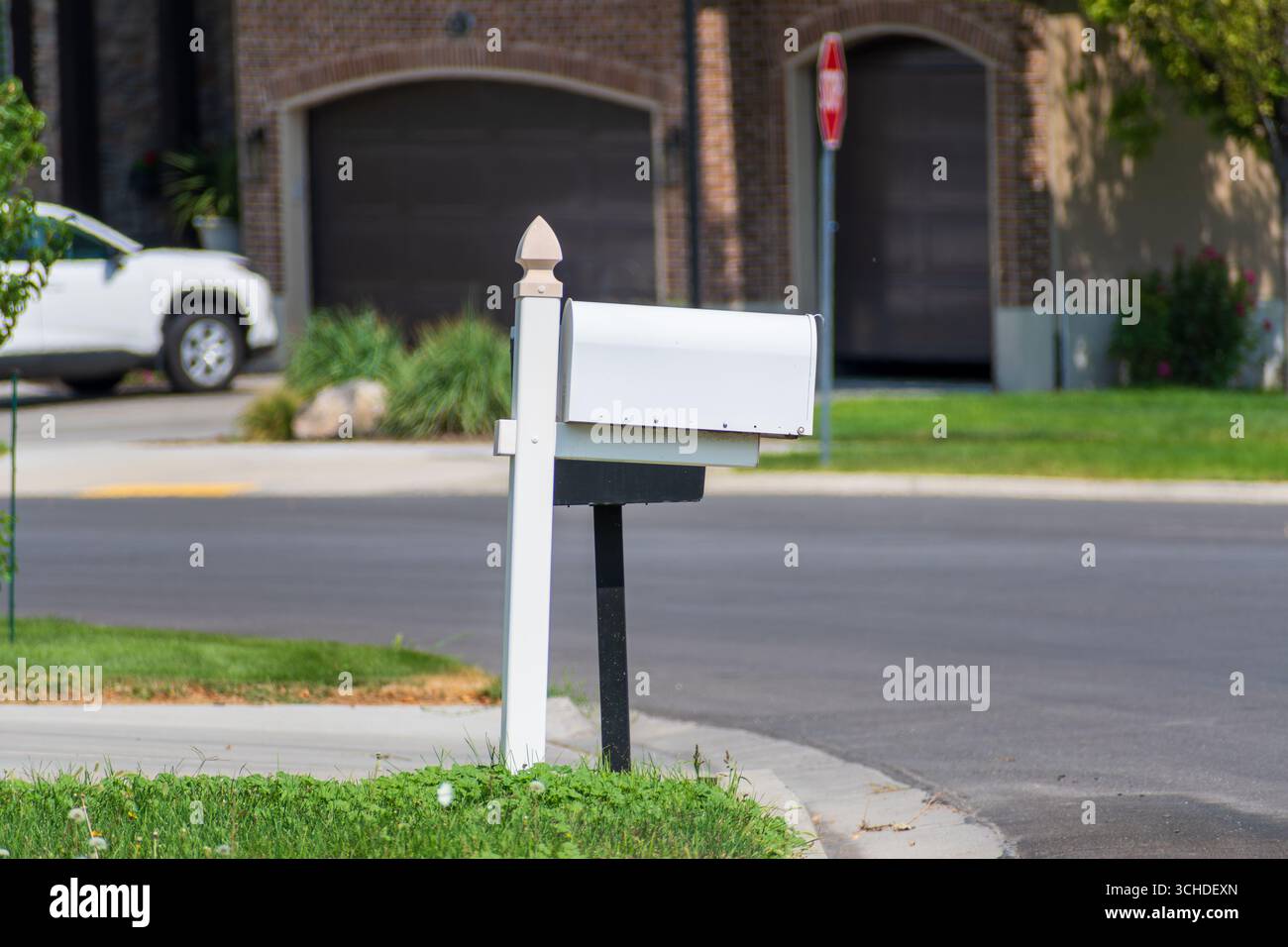 Salt Lake City, Utah, USA – 1. September 2025: Zwei Briefkästen sind an einem einzigen Posten in der Nähe einer Bordsteinkante in einem Wohnviertel montiert. Stockfoto