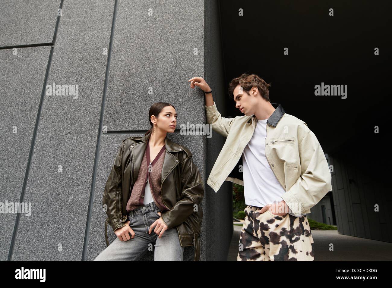 Zwei junge Liebhaber blicken in einem modernen Außenbereich, der Wärme und Zuneigung ausstrahlt. Stockfoto