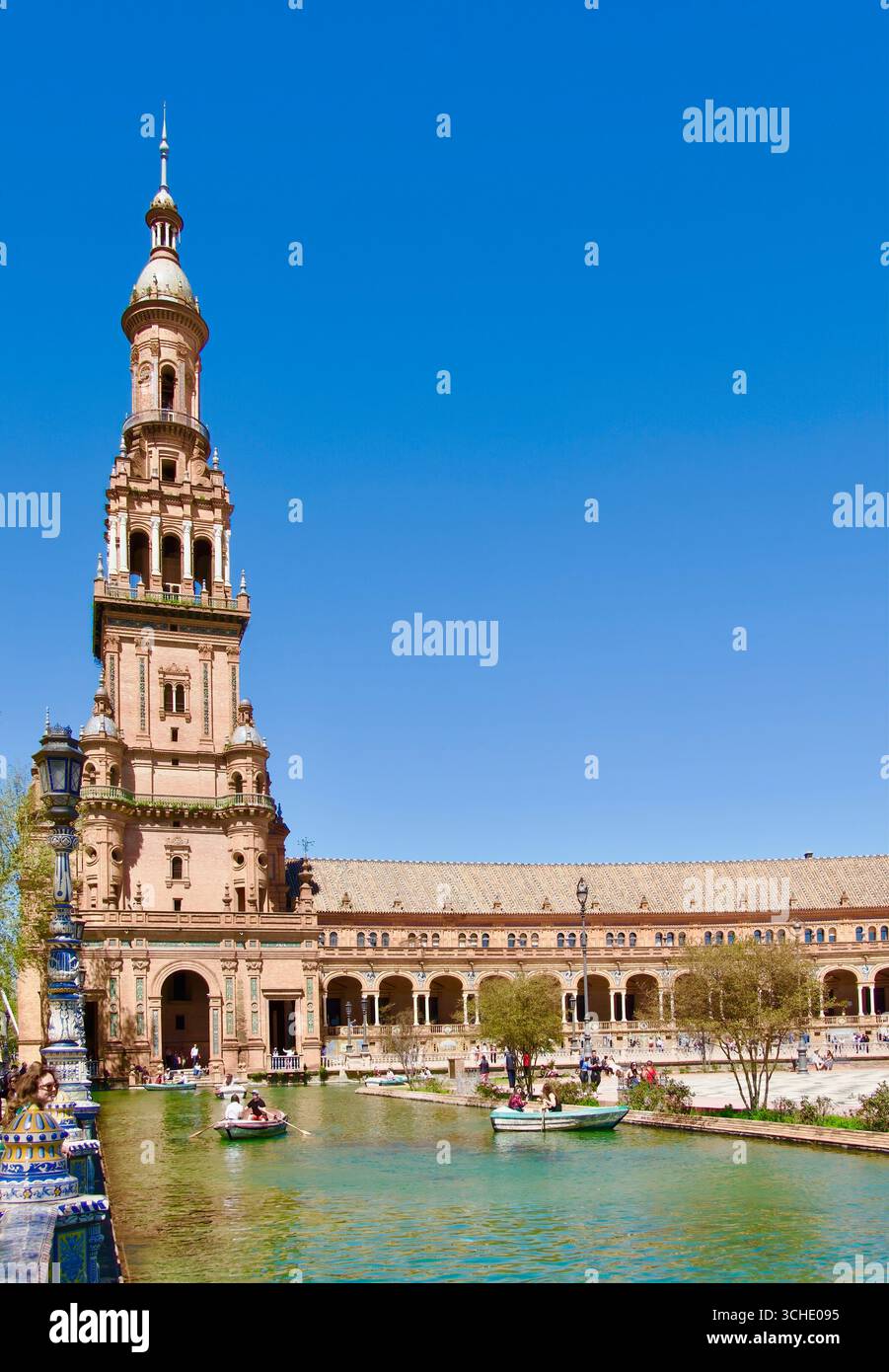 Plaza de Espana mit Ruderbooten auf dem Kanal Touristen und einer der beiden Türme am Ende des Halbkreises Maria Luisa Park Sevilla Andalusien Spanien Stockfoto