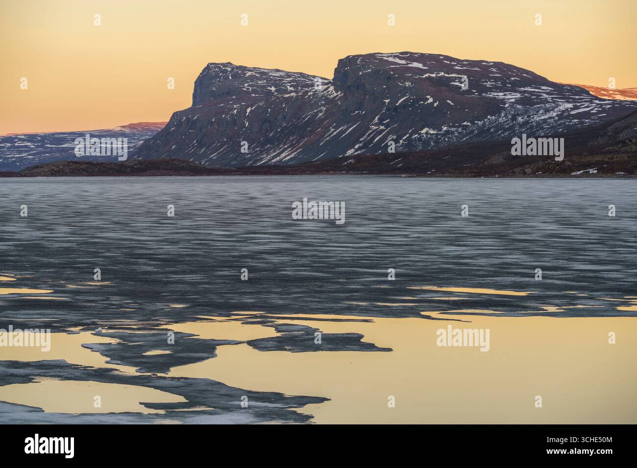 Gårtjejávrre im Stora sjöfallet Nationalpark im Frühling mit Eisschollen und farbenfrohem Himmel bei Sonnenuntergang, Schwedisch Lappland, Schweden Stockfoto