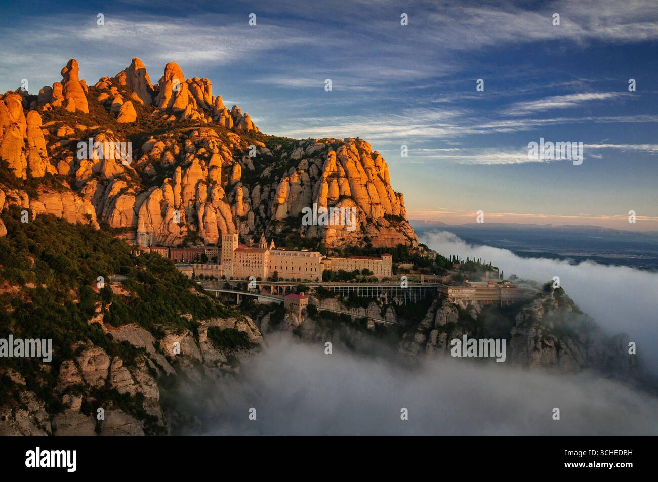 Montserrat und Kloster Montserrat bei Sonnenaufgang mit einem Meer aus Wolken vom Aussichtspunkt Creu de Sant Miquel aus gesehen (Provinz Barcelona, Katalonien, Spanien) Stockfoto