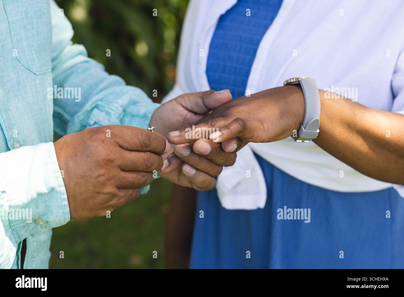 Seniorenpaar tauschen im Freien Ringe aus, feiern gemeinsam Liebe und Engagement Stockfoto