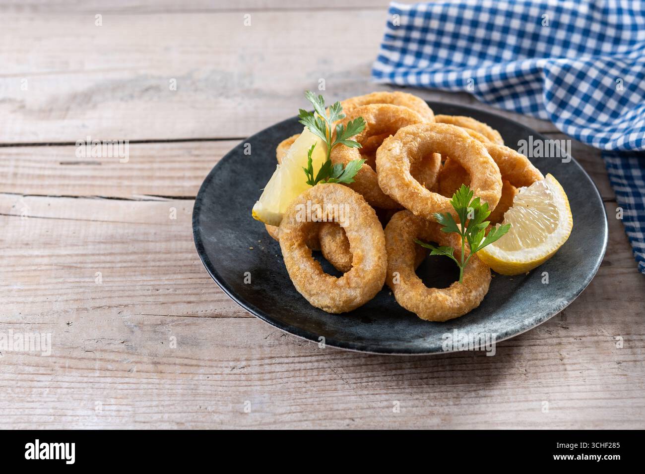 Nahaufnahme von knusprigen Calamari-Ringen, serviert auf Holztisch Stockfoto