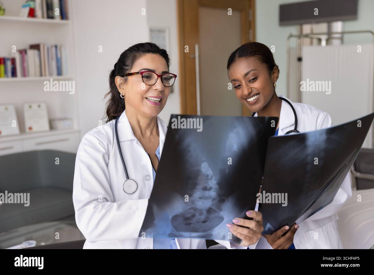 Zwei Ärztinnen untersuchen spinale Röntgenfilme in der Klinik Stockfoto