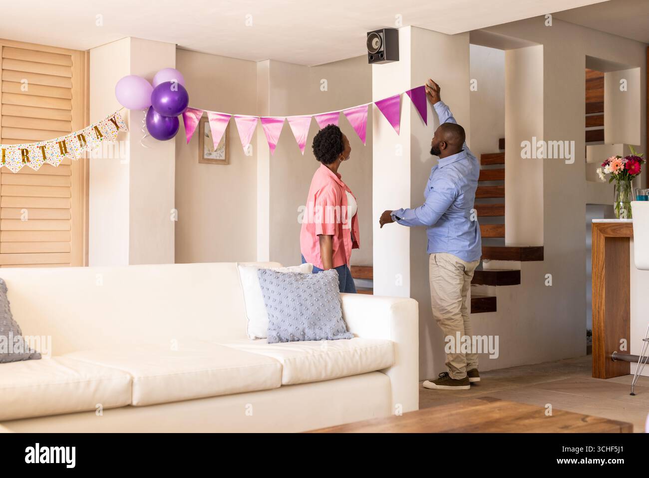 Auf der Party dekorierte Afroamerikaner das Wohnzimmer mit Geburtstagsbanner und Ballons, zu Hause Stockfoto