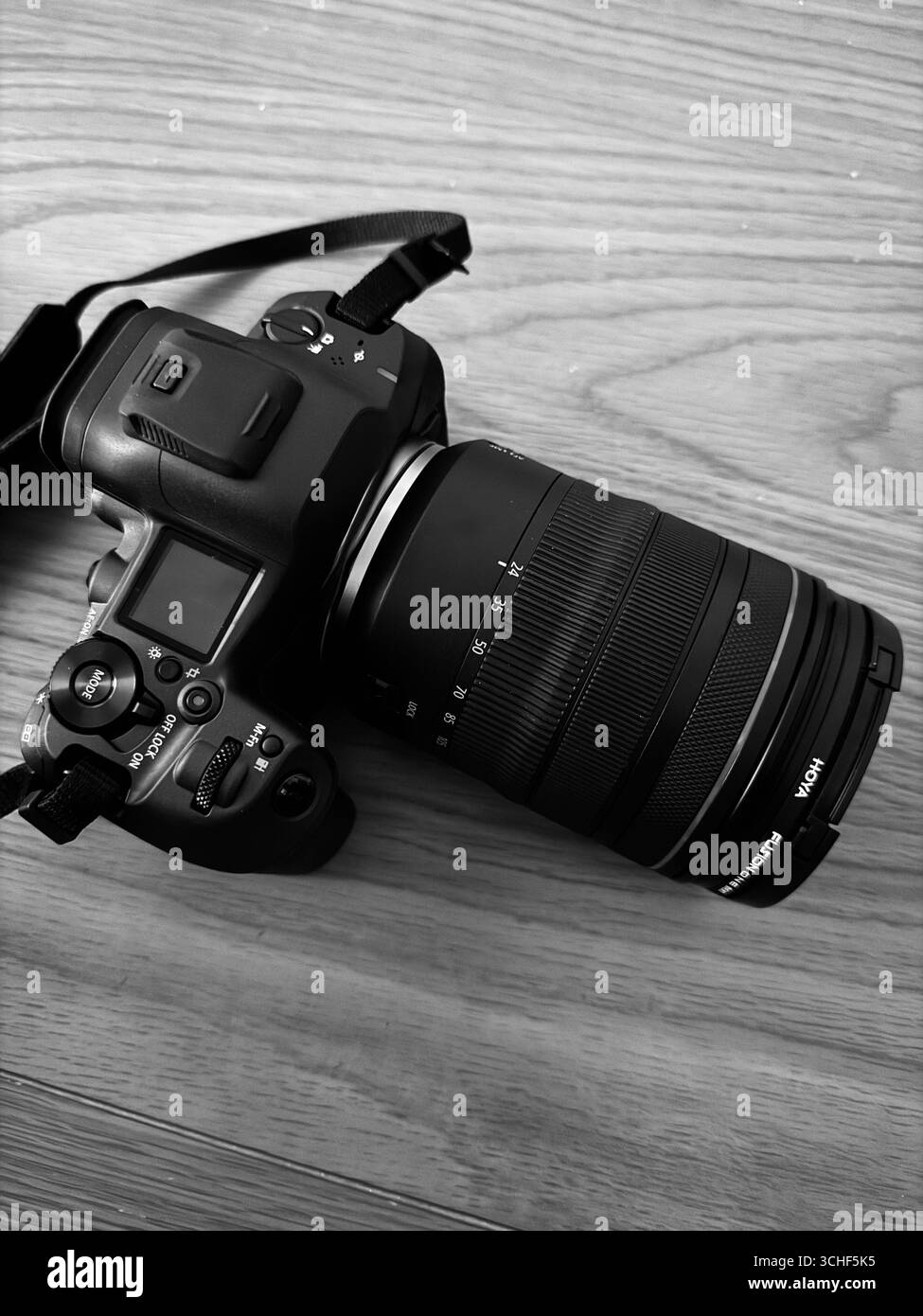 Schwarzweißfoto einer spiegellosen professionellen Kamera ohne Branding auf Holzhintergrund, Fotografie, Technologie, Bild mit kreativer Ausrüstung Stockfoto