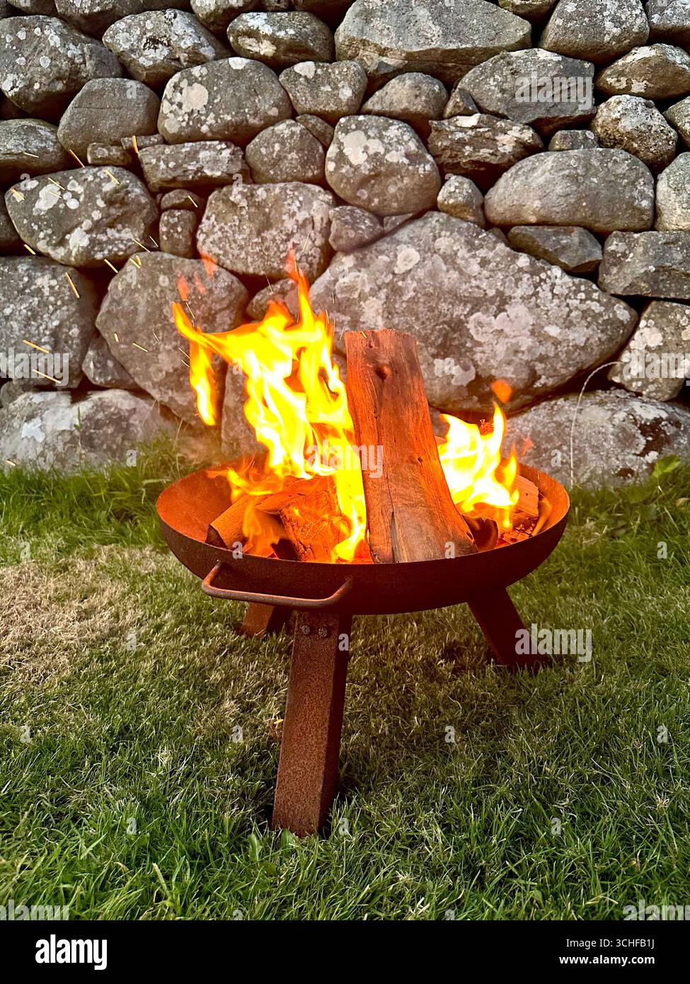 Ein Lagerfeuer aus Baumstämmen in einer Feuerschüssel Stockfoto