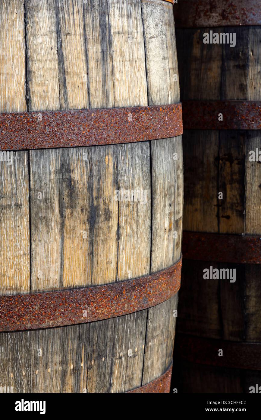 Nahaufnahme von verwitterten Whiskyfässern mit rostigen Metallreifen Stockfoto