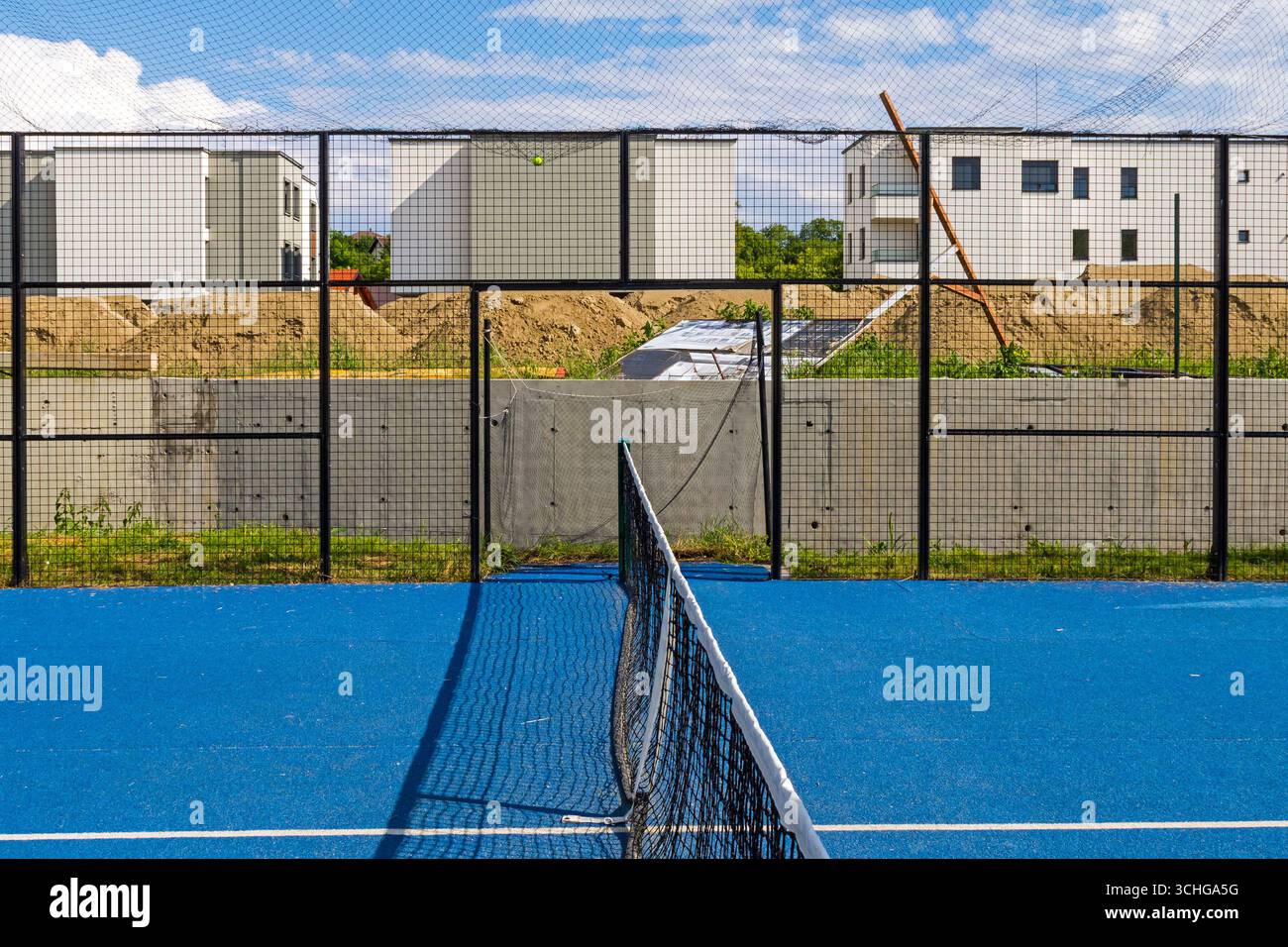 Leerer Padel-Sportplatz mit blauem Boden und Netz in der Mitte Stockfoto