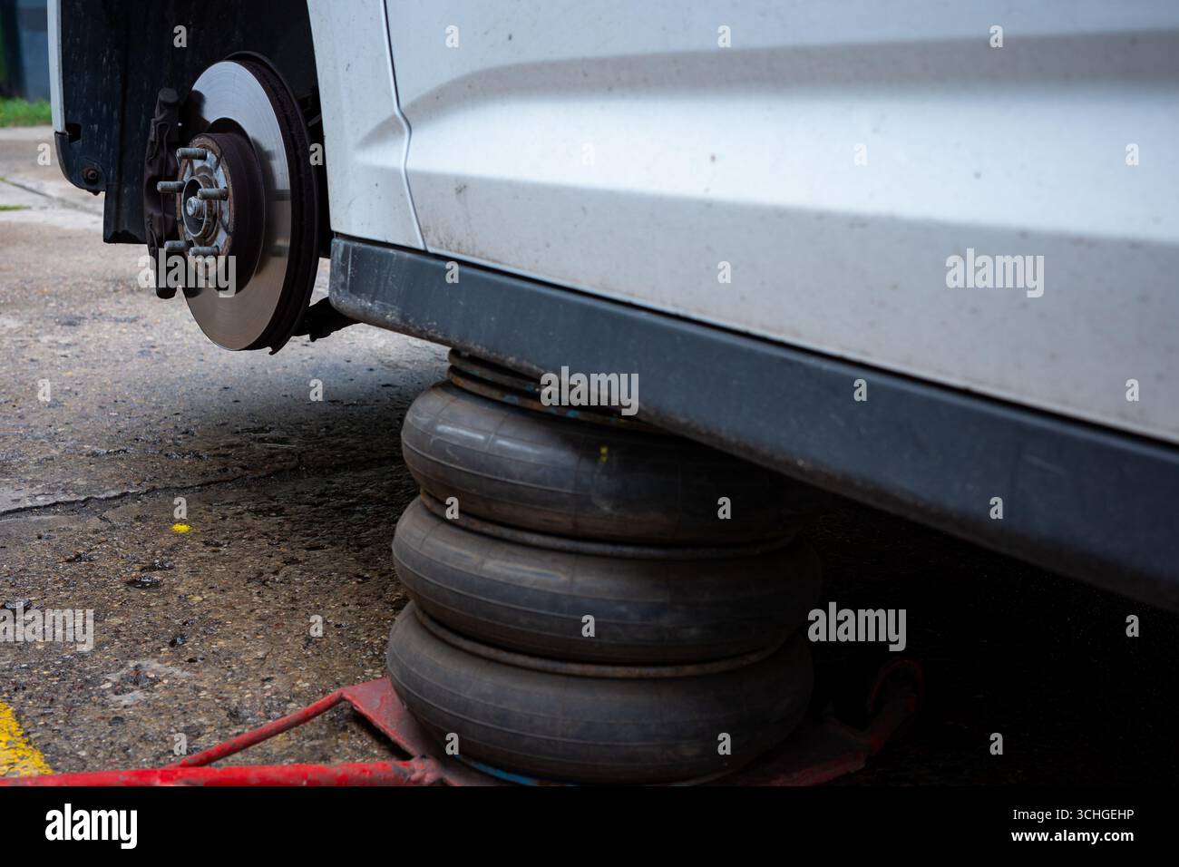 Eine pneumatische Hebevorrichtung, die das Fahrzeug in der oberen Position hält. Basiswerkzeug in der Reifenwerkstatt. Stockfoto