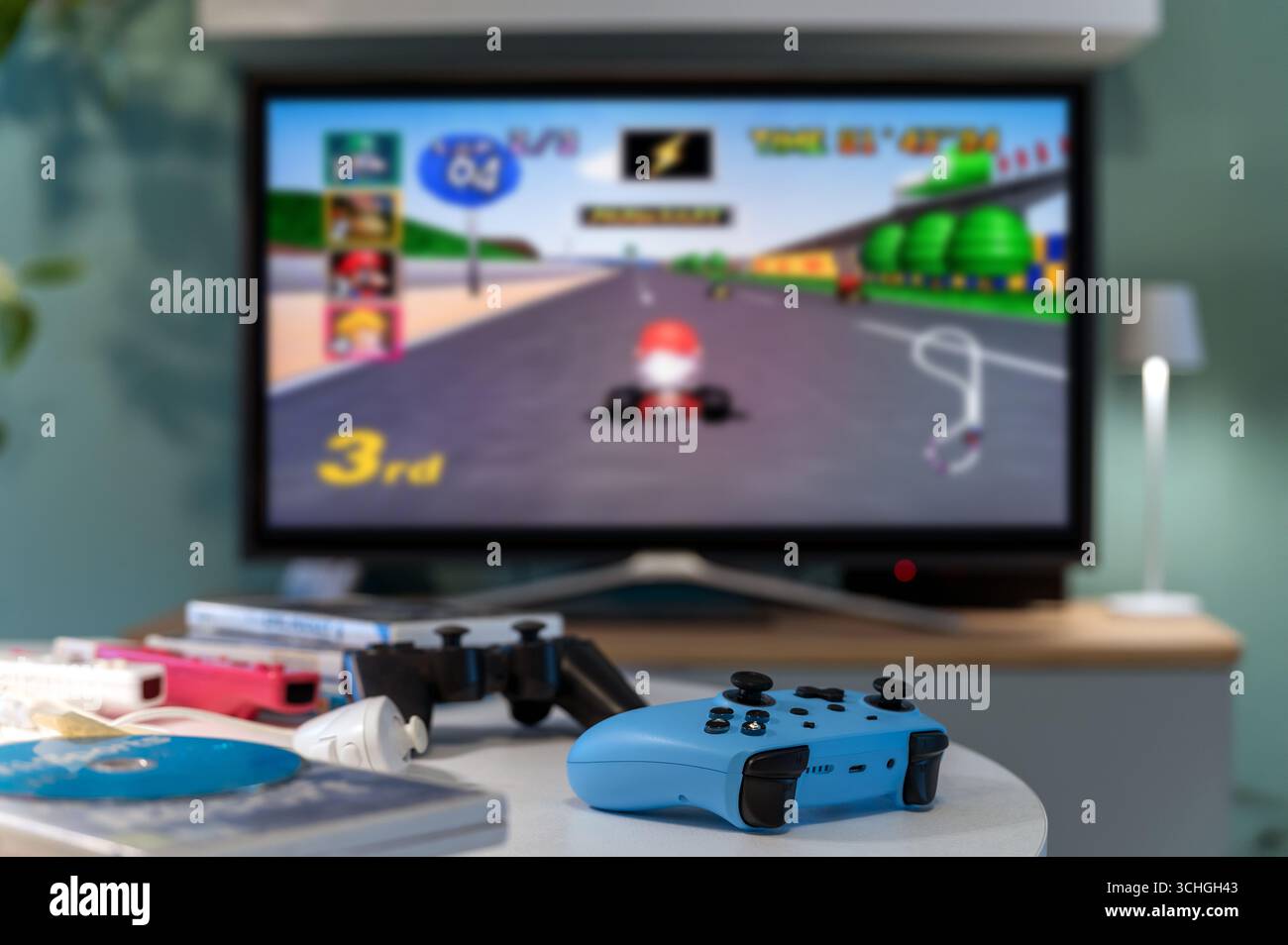 Mailand, Lombardei, Italien - 24. Februar 2025: Blauer Controller auf dem Tisch mit Mario Kart-Spiel auf dem fernsehbildschirm, das Nostalgie und Unterhaltung weckt Stockfoto