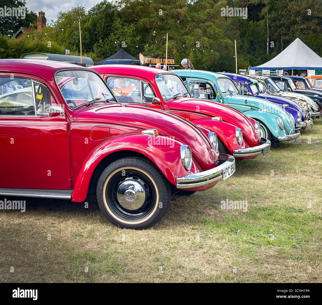 Eine farbenfrohe Reihe restaurierter, originaler Volkswagen Käfer Typ 1, die auf einer Oldtimer-Ausstellung im Freien gezeigt werden - Smartphone-aufgenommenes Stockfoto Eine farbenfrohe Reihe restaurierter, originaler Volkswagen Käfer Typ 1, die auf einer Oldtimer-Ausstellung im Freien gezeigt werden - Smartphone-aufgenommenes Stockfoto