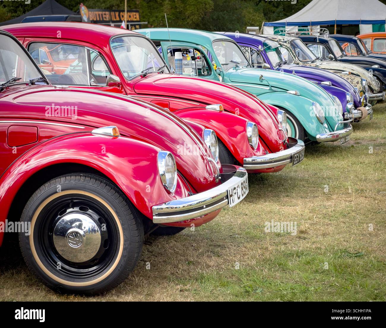 Eine farbenfrohe Reihe restaurierter, originaler Volkswagen Käfer Typ 1, die auf einer Oldtimer-Ausstellung im Freien gezeigt werden - Smartphone-aufgenommenes Stockfoto Eine farbenfrohe Reihe restaurierter, originaler Volkswagen Käfer Typ 1, die auf einer Oldtimer-Ausstellung im Freien gezeigt werden - Smartphone-aufgenommenes Stockfoto