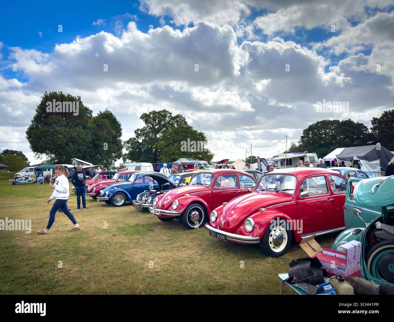 Eine farbenfrohe Reihe restaurierter, originaler Volkswagen Käfer Typ 1, die auf einer Oldtimer-Ausstellung im Freien gezeigt werden - Smartphone-aufgenommenes Stockfoto Eine farbenfrohe Reihe restaurierter, originaler Volkswagen Käfer Typ 1, die auf einer Oldtimer-Ausstellung im Freien gezeigt werden - Smartphone-aufgenommenes Stockfoto