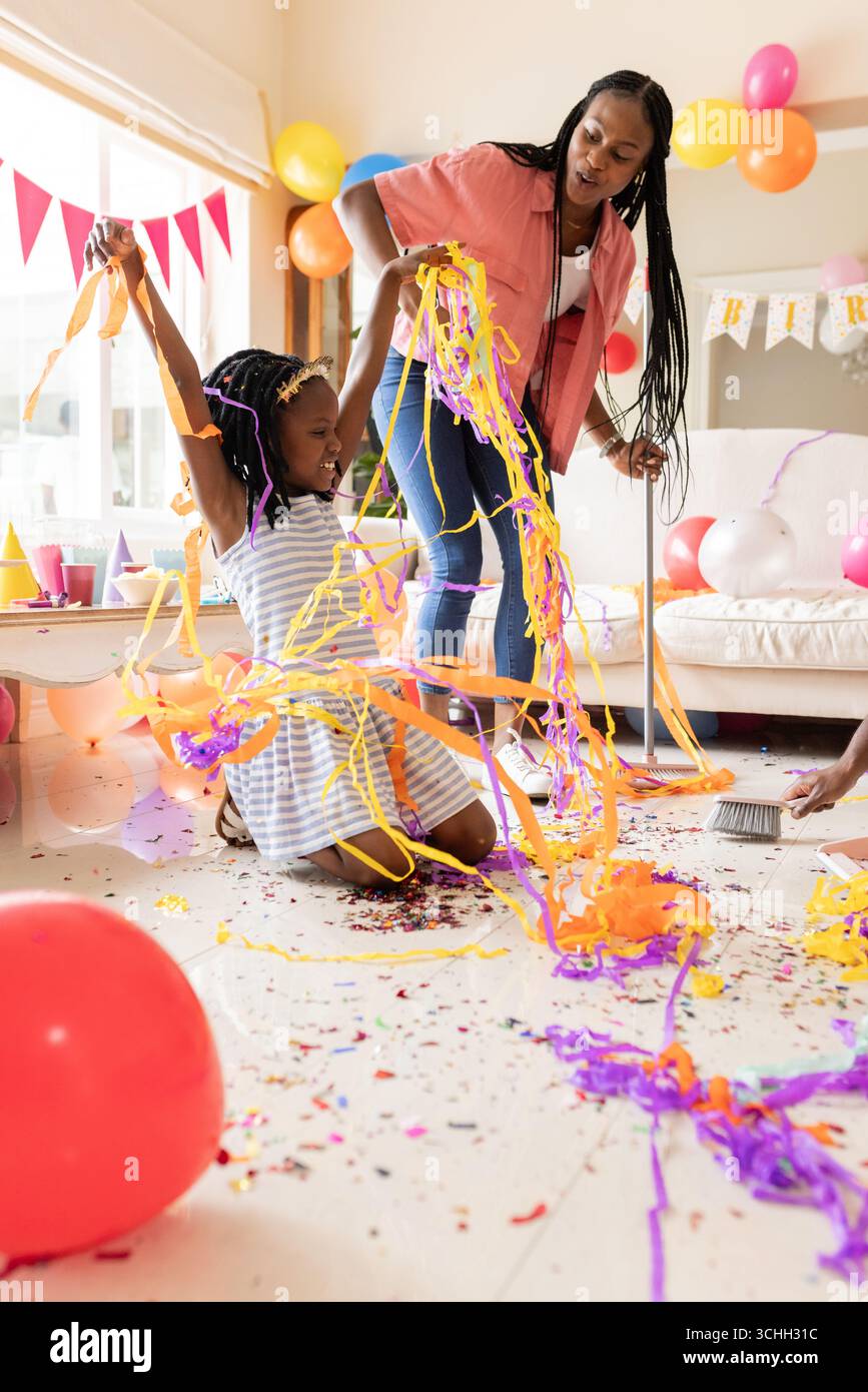 Feiern Sie Geburtstag mit bunten Streamers, afroamerikanischer Mutter und Kind zu Hause Stockfoto