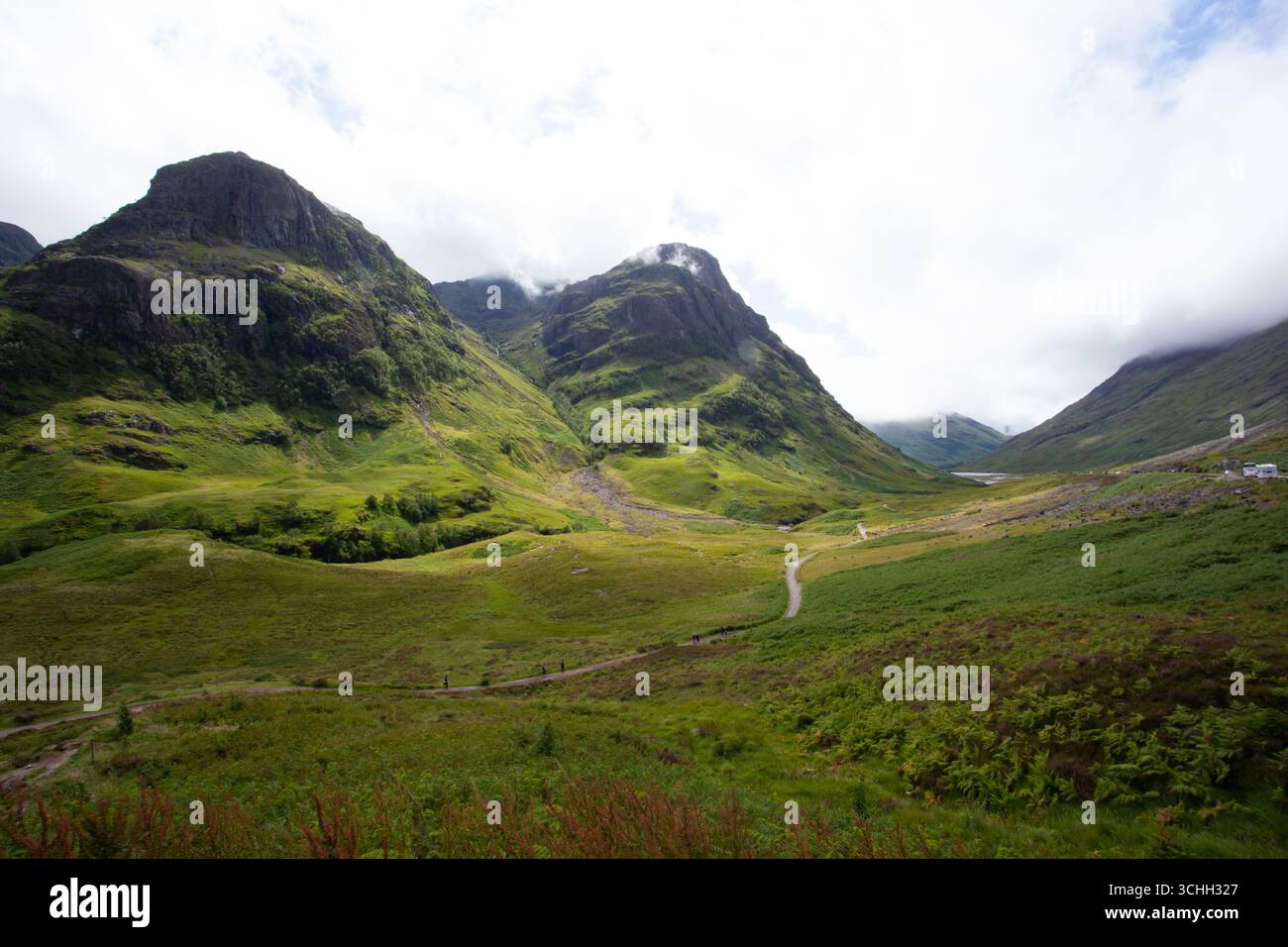 Malerischer Blick auf das Glencoe Valley in den schottischen Highlands mit üppigen grünen Hügeln, ein Wanderweg durch die Landschaft. Stockfoto