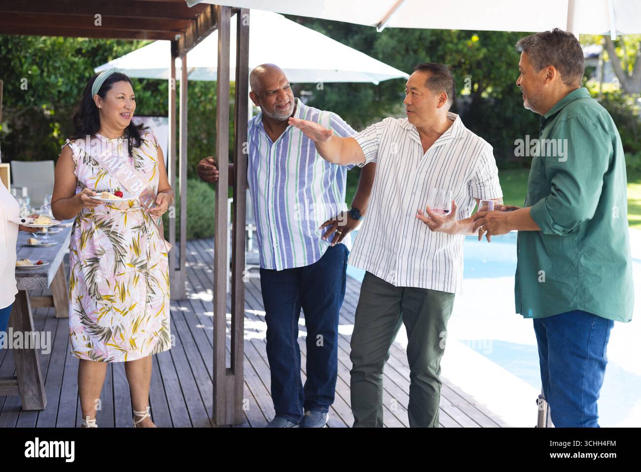 Gruppe von Senioren, die sich gerne im Freien treffen, lachen und Geschichten am Pool teilen Stockfoto