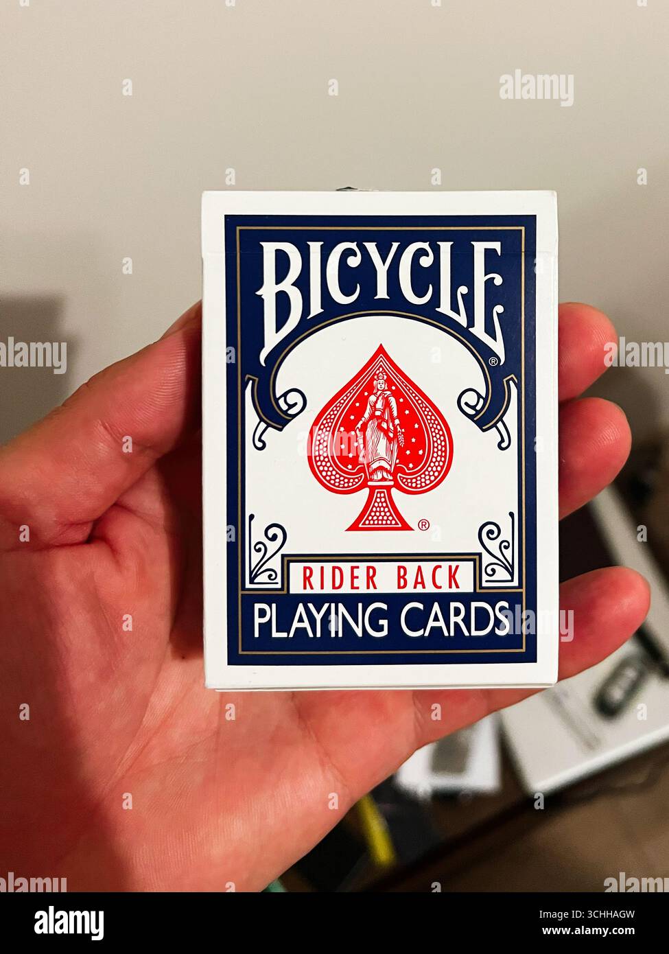Rzeszow, Polen - 22. August 2025: Hand hält ein Standard-Fahrrad-Spielkartenpaket vor einem minimalen Hintergrund Stockfoto