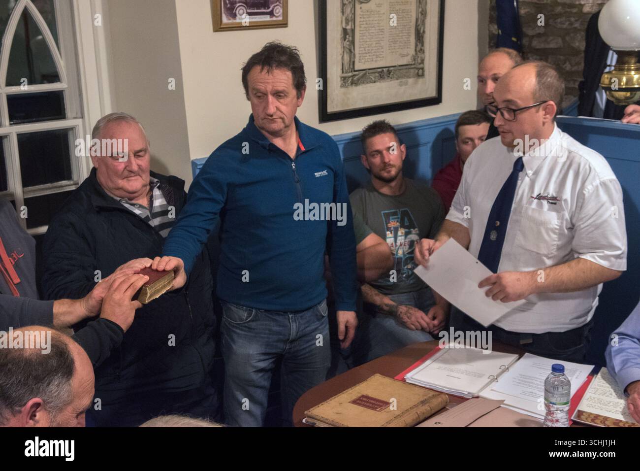 Einen Eid mit der Hand auf eine Bibel schwören. Die jährliche Wahl des neuen Portreeve von Laugharne findet am ersten Montag nach Michaelmas im Großen Hof des Rathauses statt. Ein neu gewählter Vertreter wird vereidigt. Der Hof bestand aus dem Portreeve, den Stadträten und dem Körper von Burgessen, die die Überreste des mittelalterlichen Freifeldsystems Laugharne verwalten. Das Land gehört der Stadt und wird heute für die Weide von Rindern genutzt. Laugharne, Carmarthen, Wales, 30. September 2019 Vereinigtes Königreich 2010er HOMER SYKES Stockfoto