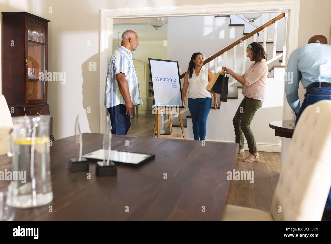 Familie begrüßt Gäste zu Hause, tauscht Geschenke aus und genießt warme Gespräche Stockfoto