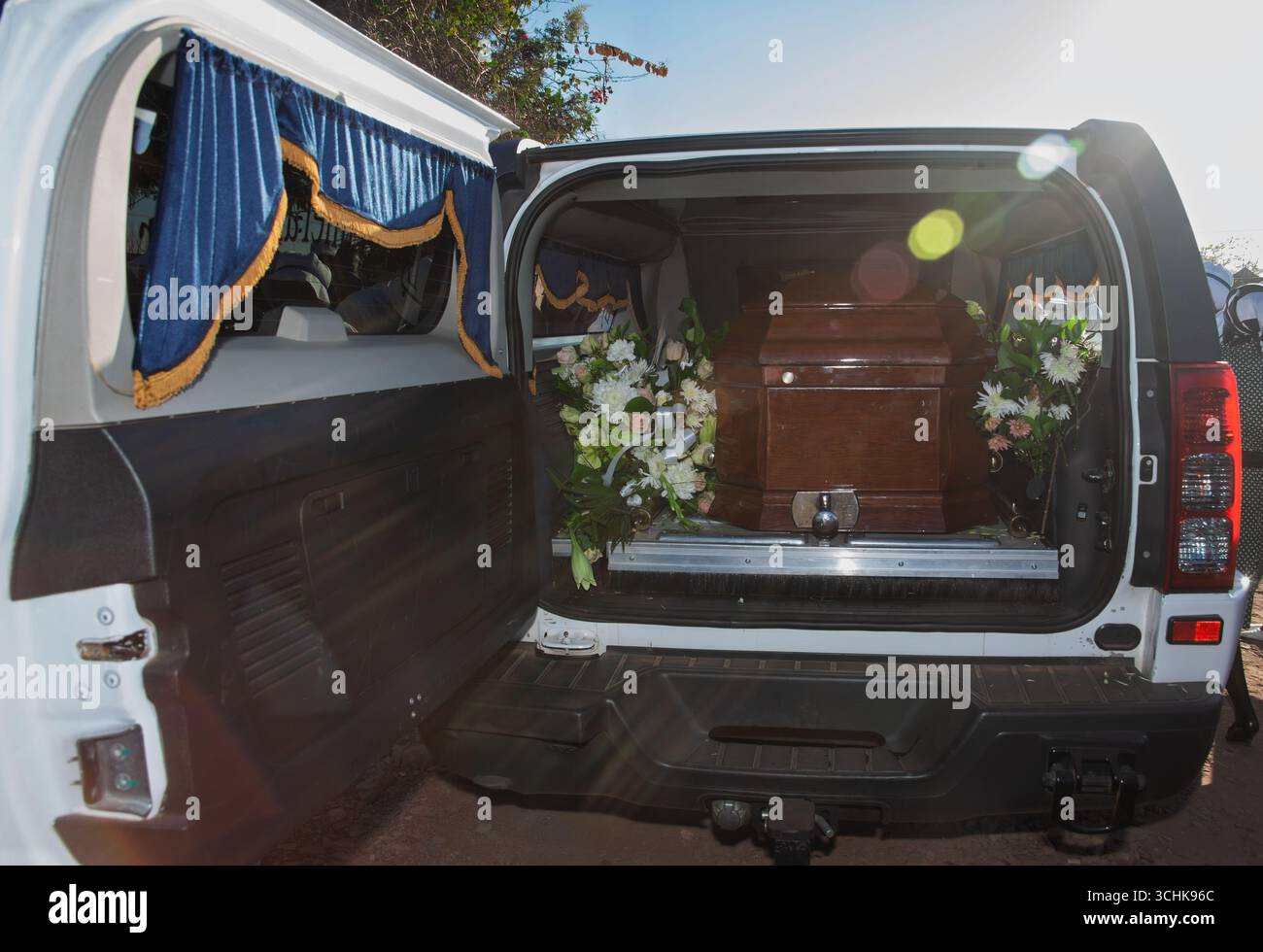 Leichenwagen mit Sarg und Leiche im Inneren, Leichenwagen umgeben von Blumen, Transport des Begräbnisdienstes Stockfoto