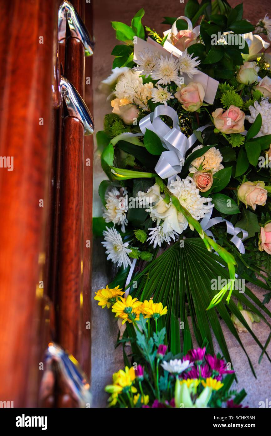 Sarg und Blumen, luxuriöser Holzschatulle und Blumenstrauß aus Blumen, Rosen und Nelken Stockfoto