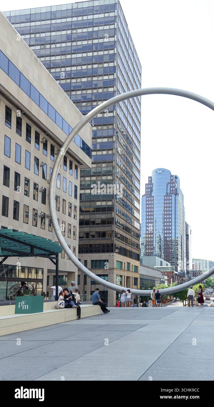 Montreal QC, Kanada - 20. Juli 2025: Die Ringskulptur am Place Ville Marie in Montreal, umrahmt von zeitgenössischen Gebäuden und lebhaften Straßenaktivitäten Stockfoto