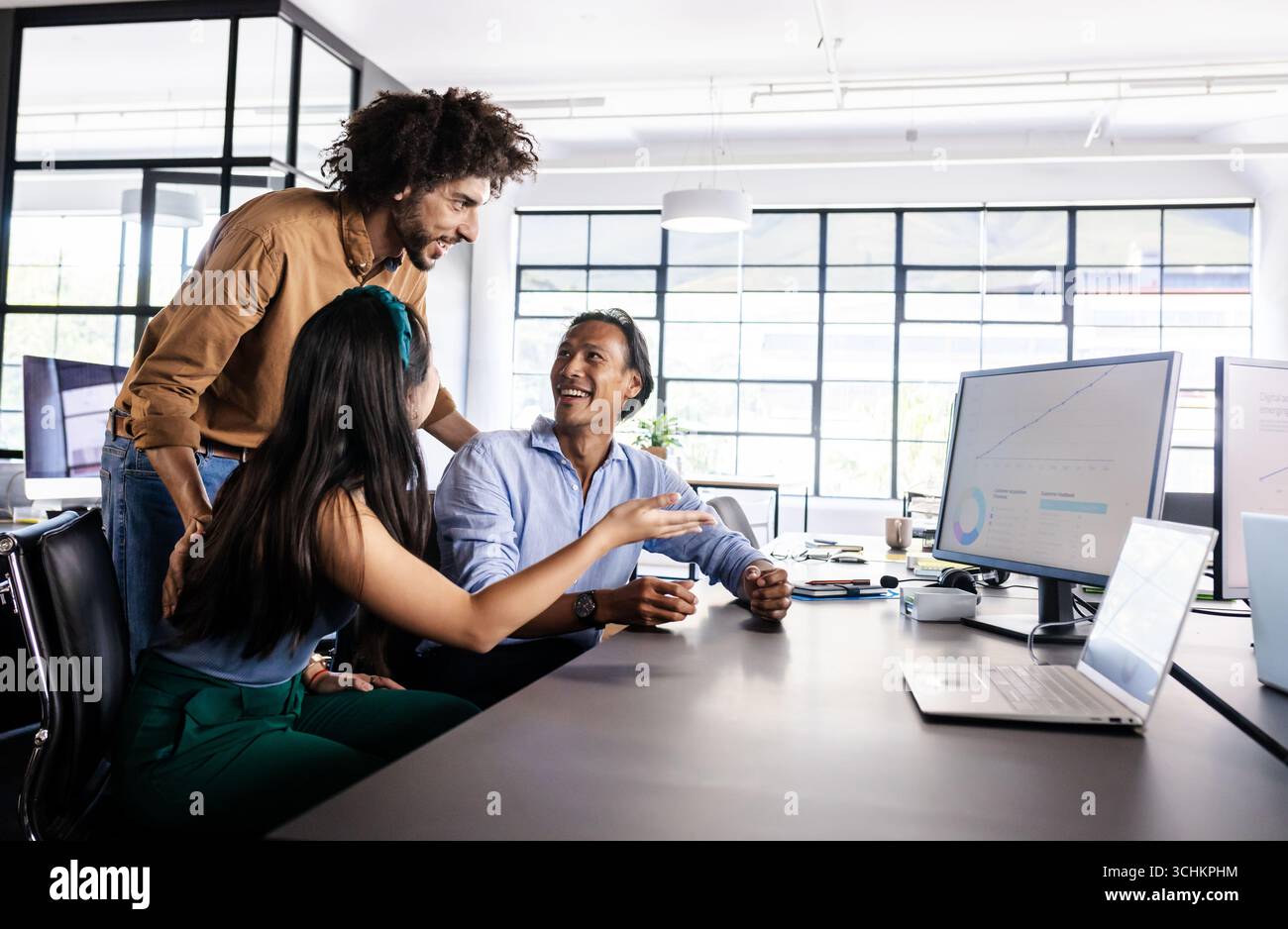 Vielfältige Teams arbeiten am Bürotisch zusammen, diskutieren Projekte mit Begeisterung Stockfoto