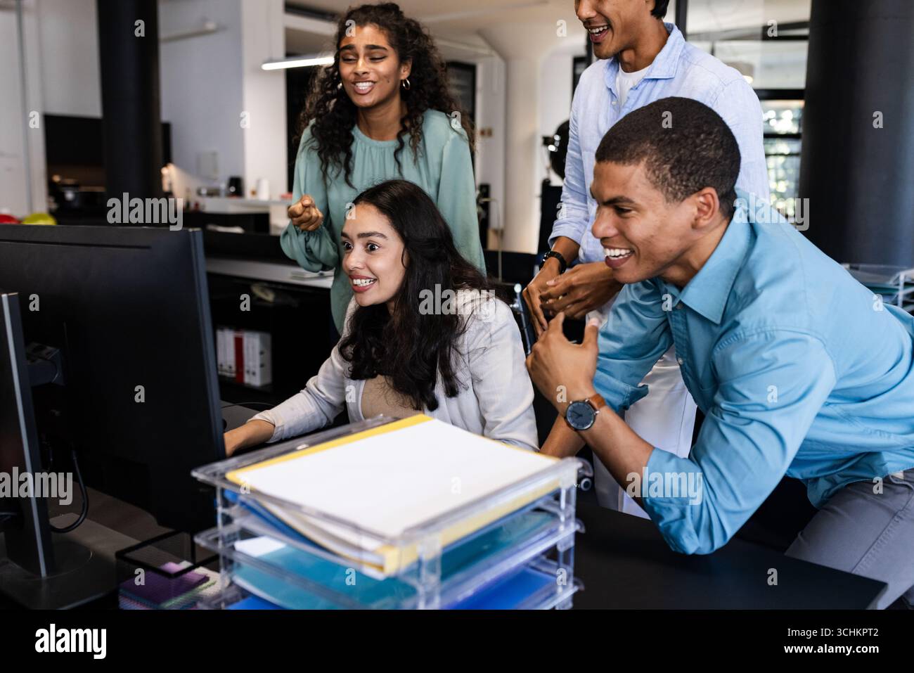 Im Büro arbeiten verschiedene Teams rund um den Computer zusammen und konzentrieren sich dabei auf die Projektarbeit Stockfoto
