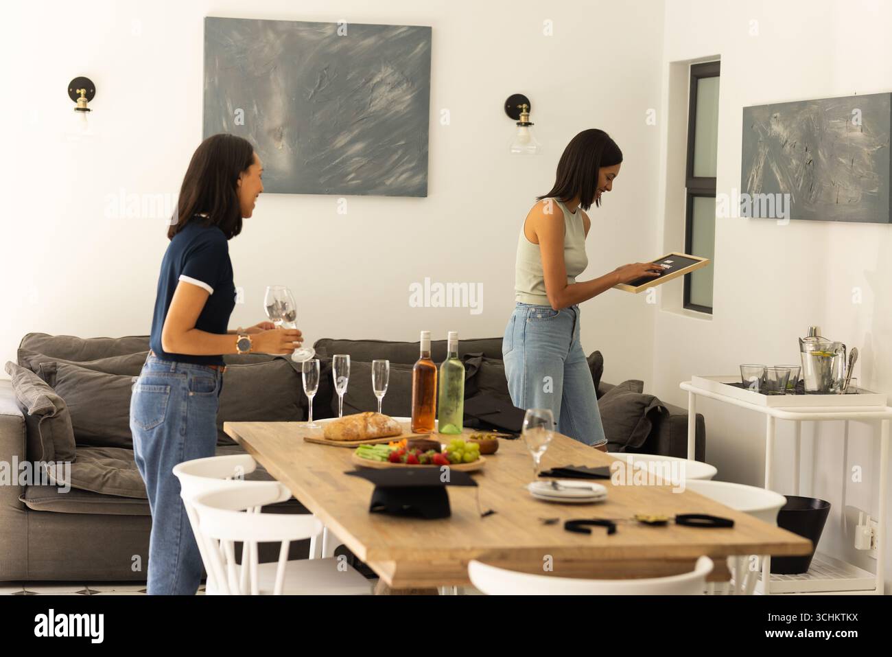 Zwei junge Frauen mit mittleren Hauttönen genießen einen entspannten Nachmittag zu Hause Stockfoto