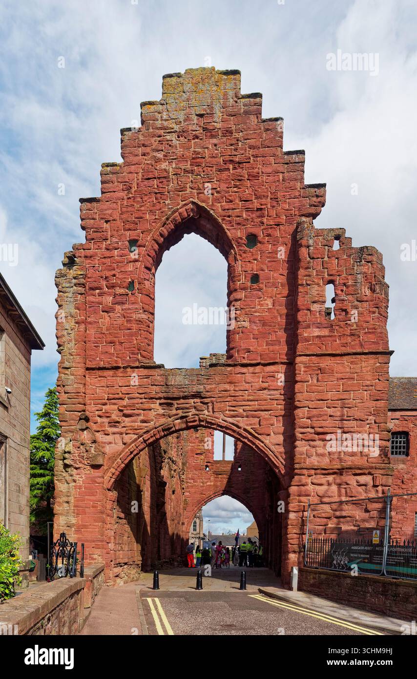 Der abgerundete Bogen der Westfront, der heute noch von Arbroath Abbey übrig bleibt, mit Teilnehmern an einem Pride March-Treffen vor dem Besucher CE Stockfoto