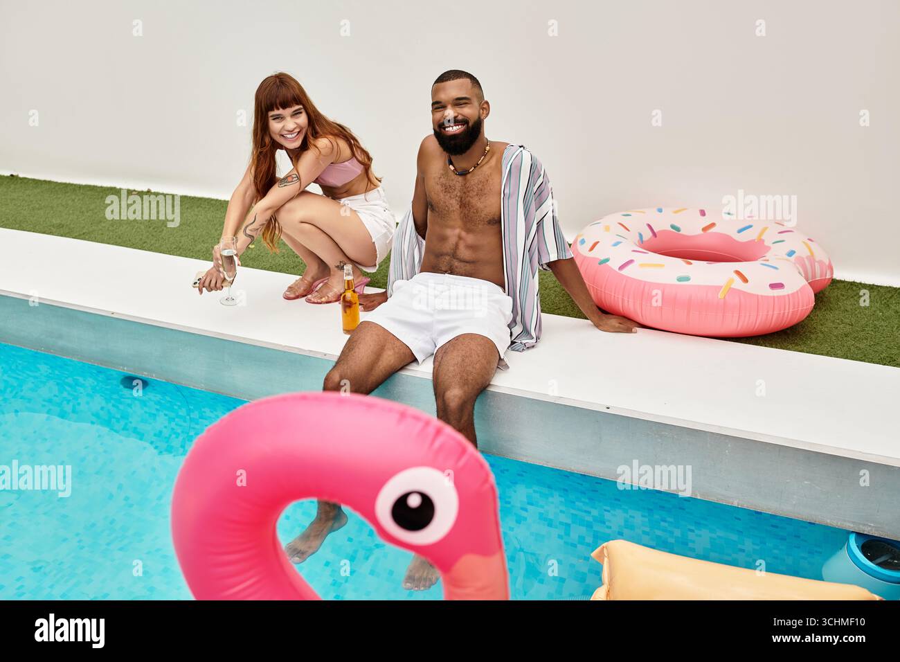 Junge Freunde genießen Lachen und Getränke, während sie an einer lebhaften Poolparty voller Energie teilnehmen. Stockfoto