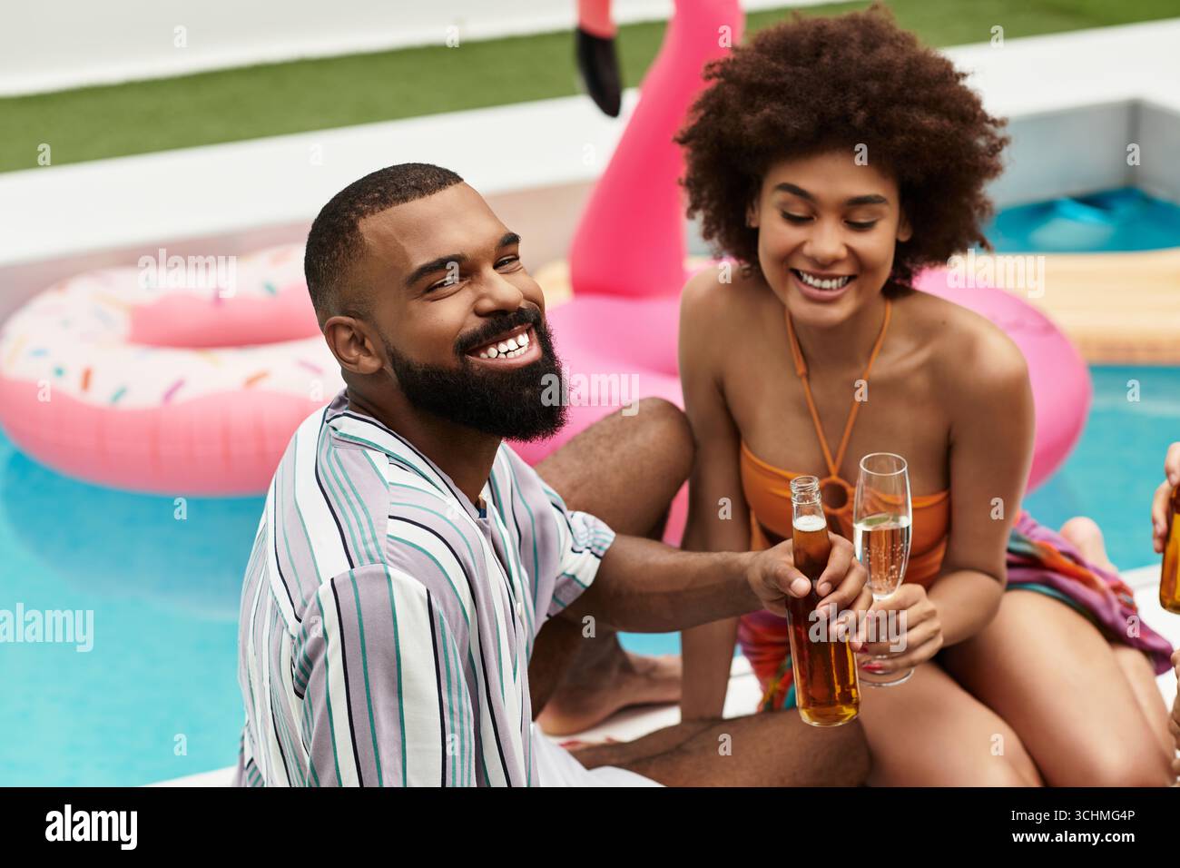 Junge Freunde genießen gemeinsam Drinks und Lachen bei einer lebhaften Poolparty unter der Sonne. Stockfoto
