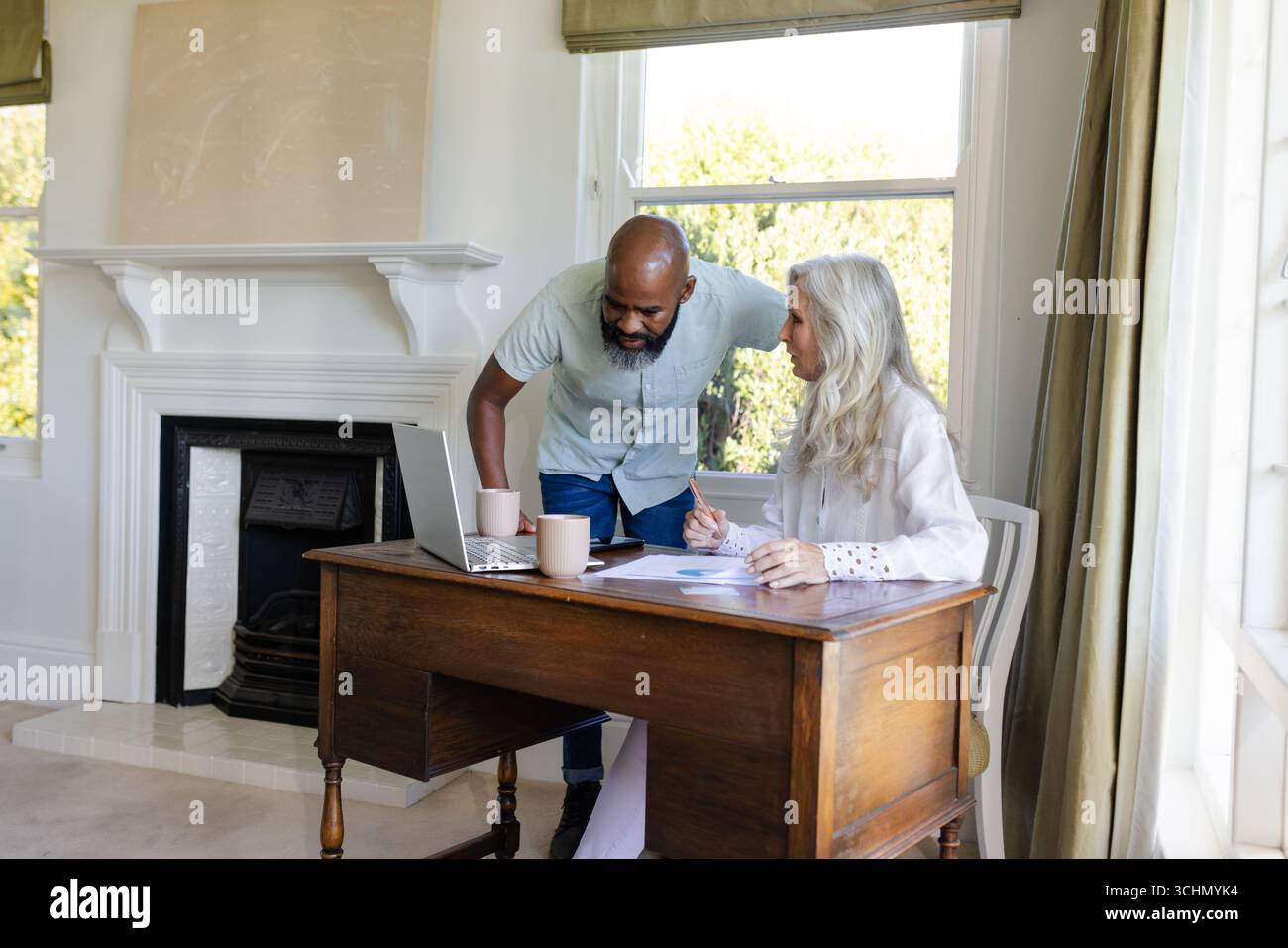 Zusammenarbeit im Heimbüro, afroamerikanischer Mann und Frau mit Laptop, Dokumenten Stockfoto