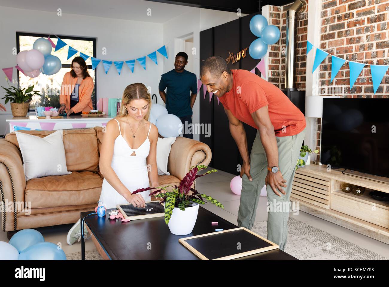 Babydusche, verschiedene Freunde, die für Partys zu Hause dekorieren, Ballons und Banner arrangieren Stockfoto