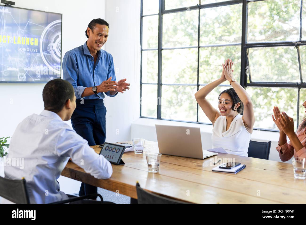 Business Diversity Team feiert erfolgreichen Projektstart im modernen Konferenzraum im Büro Stockfoto