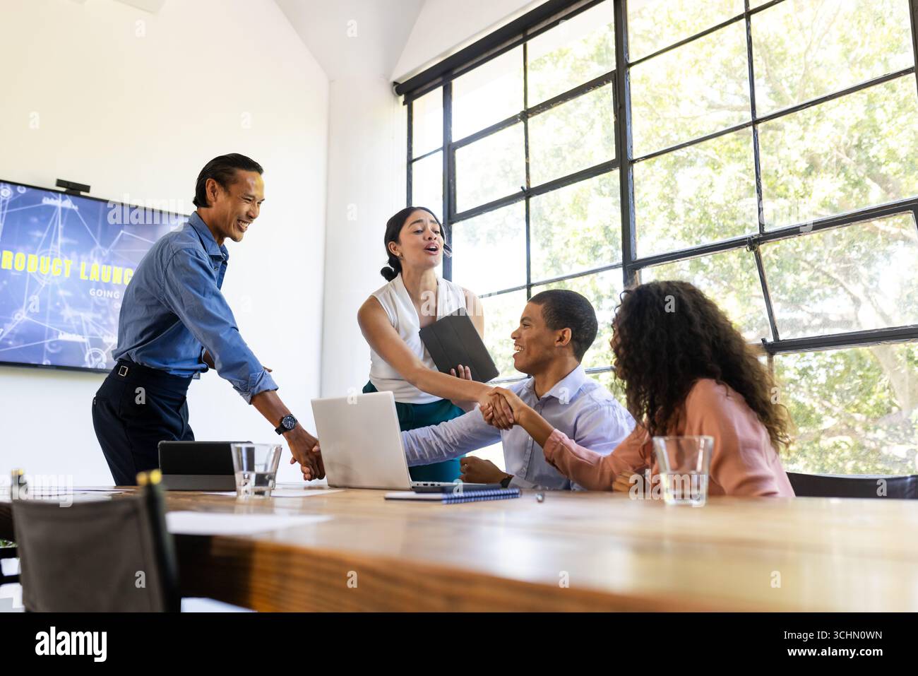 Wir feiern die erfolgreiche Produkteinführung, ein vielfältiges Business-Team im modernen Konferenzraum, im Büro Stockfoto