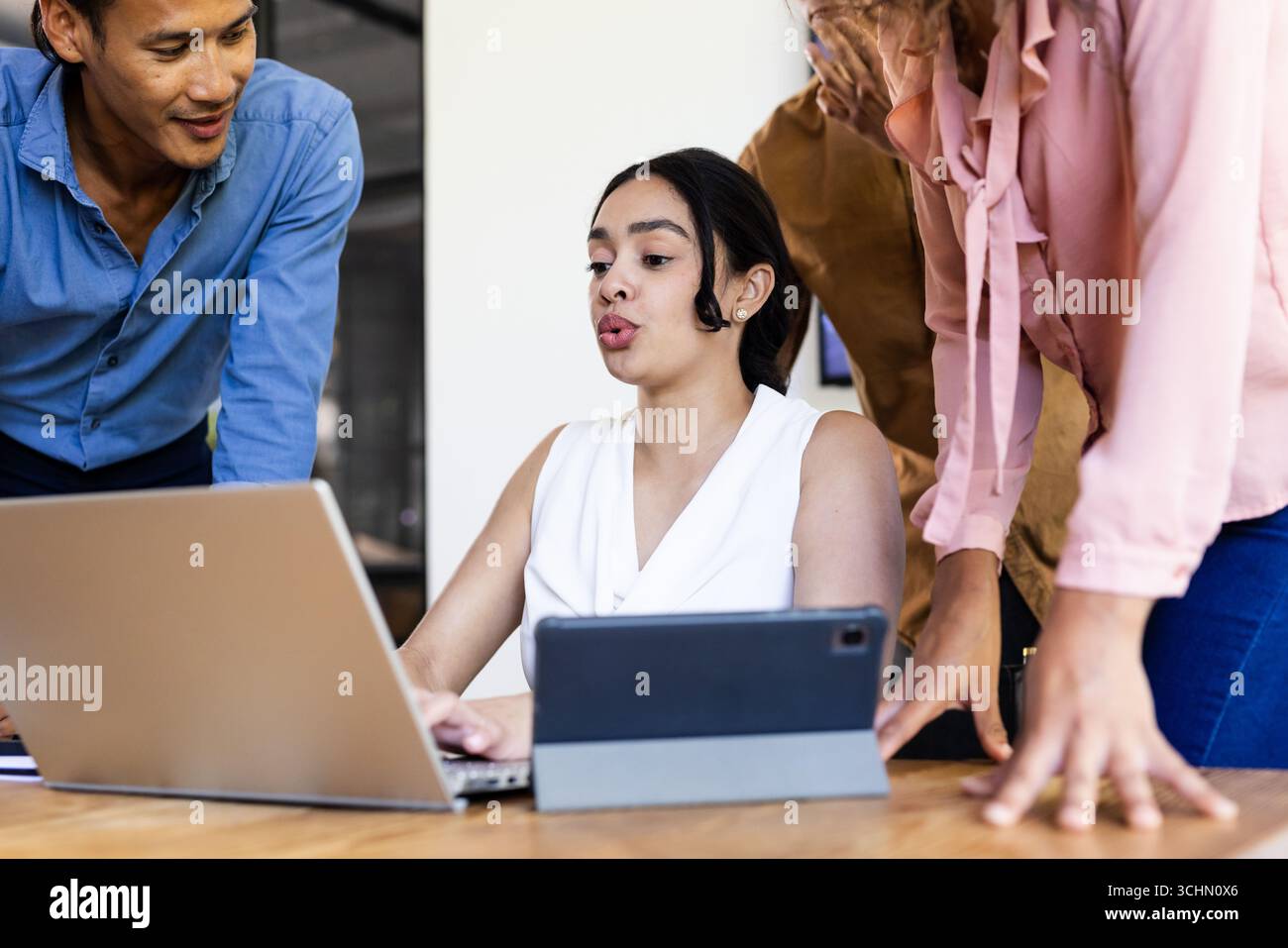 Business Diversity Team arbeitet in modernen Büros rund um Notebooks und Tablets zusammen Stockfoto