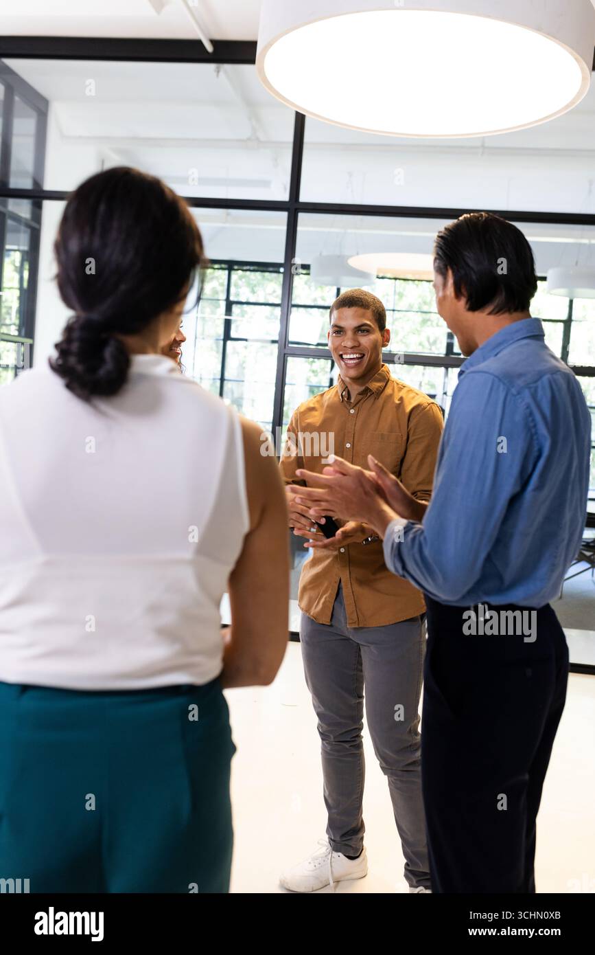 Vielseitiges Geschäftsteam diskutiert Ideen im modernen Büro, lächelt und engagiert Stockfoto
