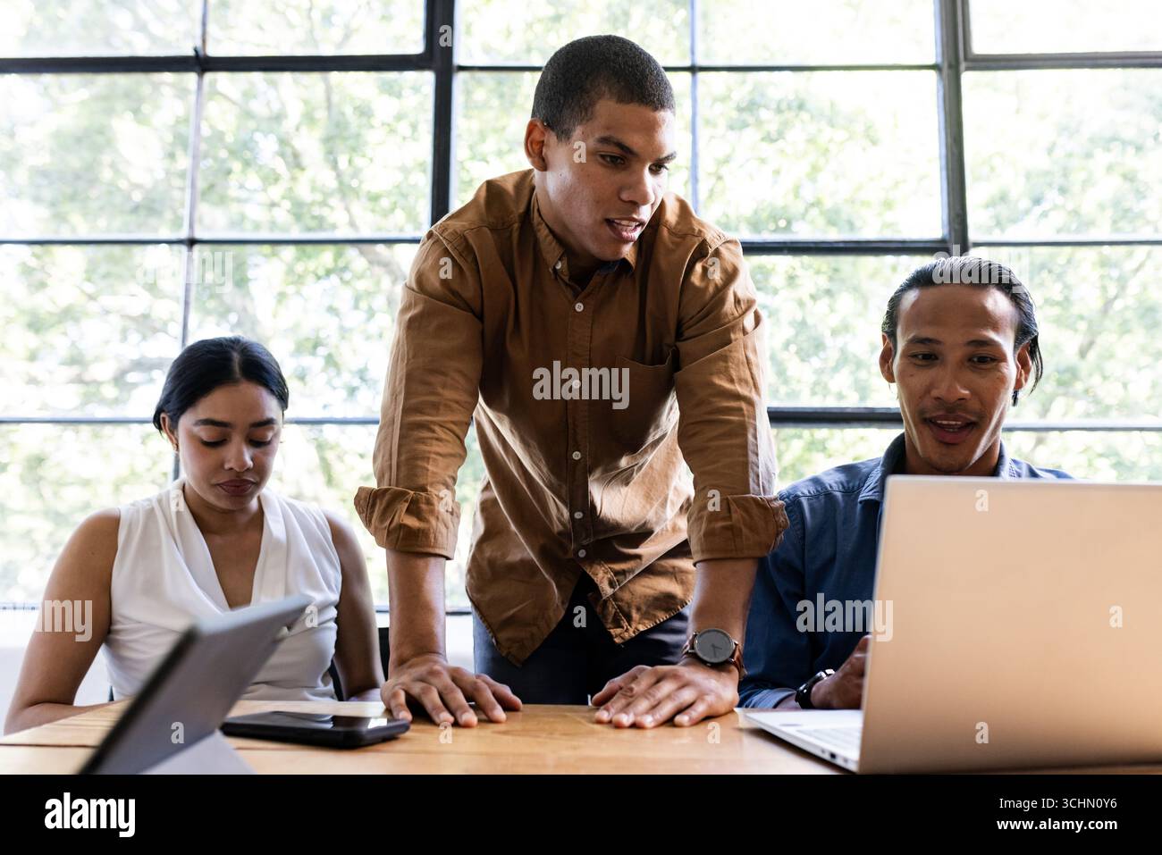Verschiedene Teams arbeiten an Projekten mit Laptops in moderner Büroumgebung zusammen Stockfoto
