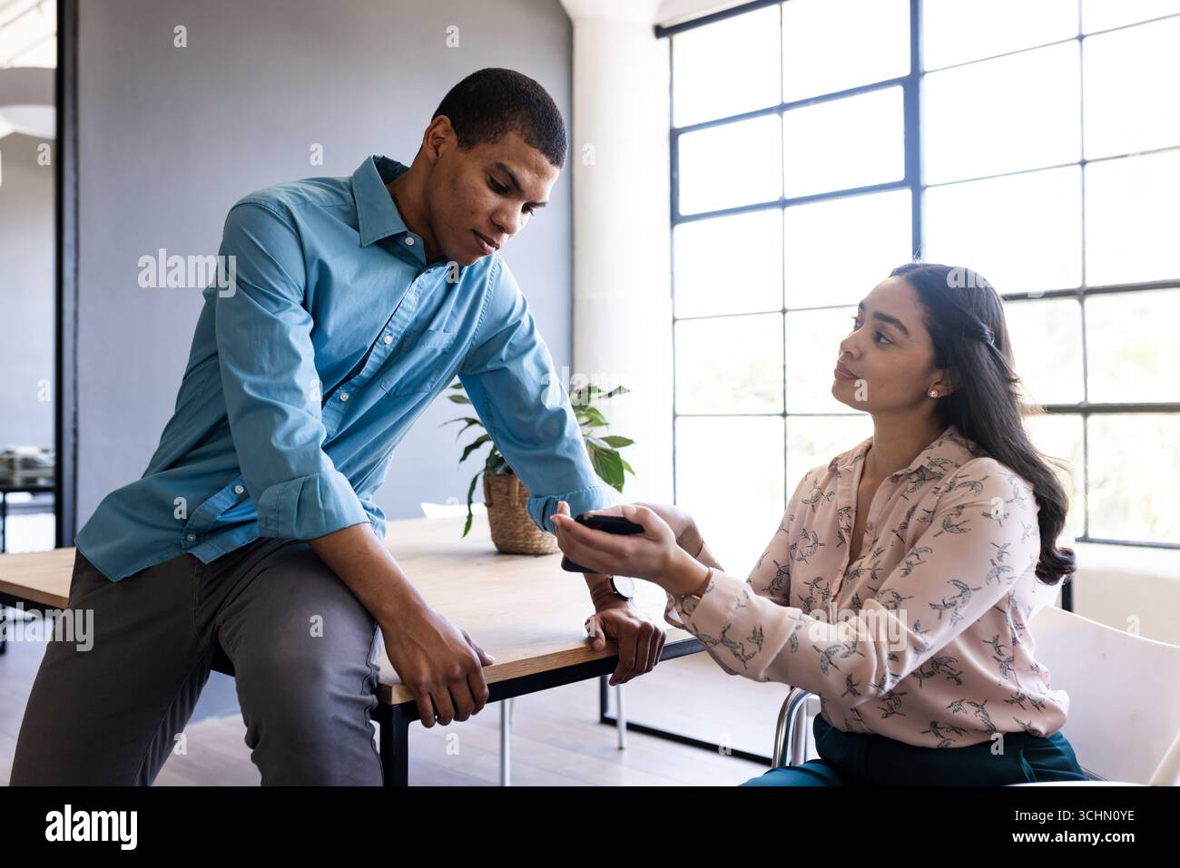 Sprechen Sie über die Geschäftsstrategie, Mann und Frau nutzen das Smartphone im Büro Stockfoto