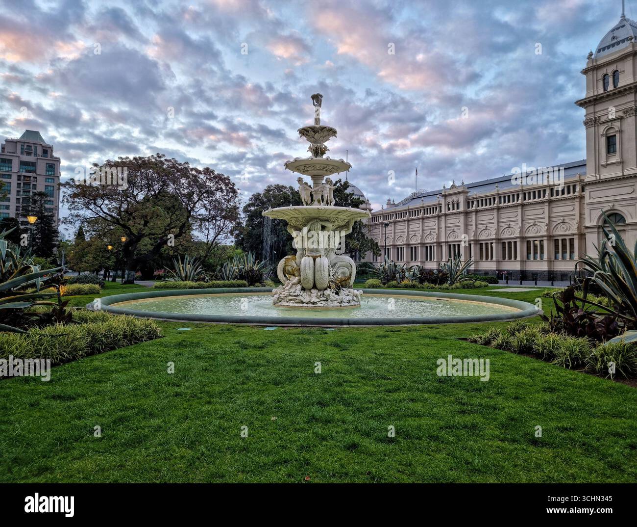 Historischer Gartenbrunnen vor dem großen Gebäude aus der Kolonialzeit, Melbourne, Australien - Smartphone-aufgenommenes Stockfoto