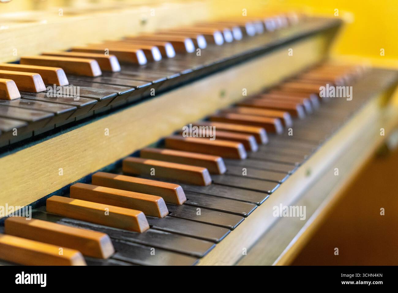 Antike Orgeltastatur und Bedienelemente in einer lutherischen Kirche. Notenblätter mit Notizen liegen auf dem Ständer. Stockfoto