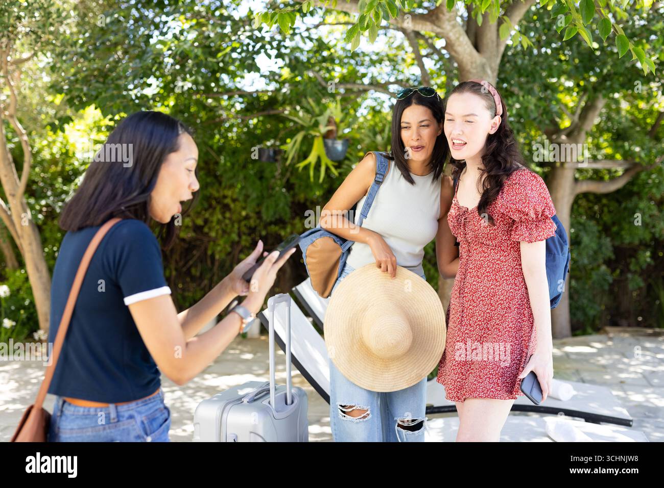 Mit Selfie genießen drei junge Frauen einen sonnigen Tag im Freien mit Gepäck Stockfoto