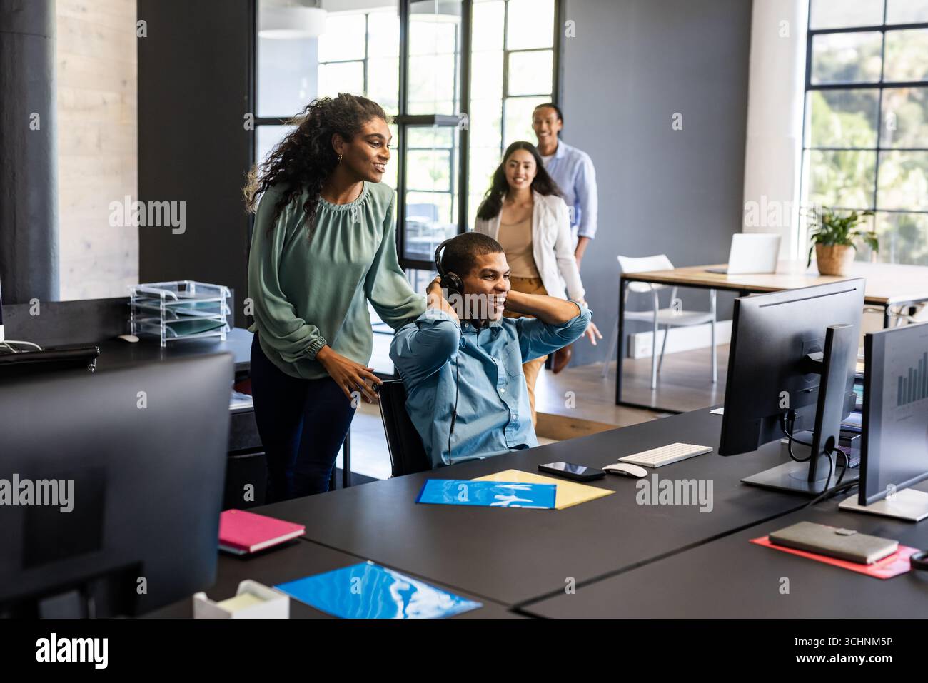 Zusammenarbeit bei Projektideen, lächelndes Team in moderner Büroumgebung Stockfoto